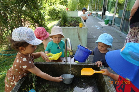 Kinder spielen am Brunnen